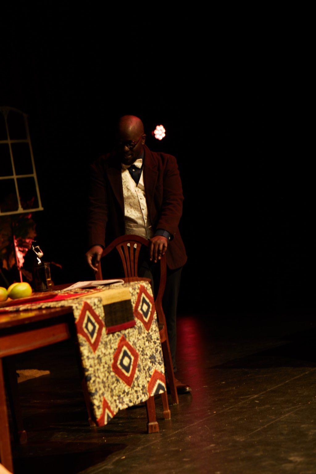 Production still — solitary table scene